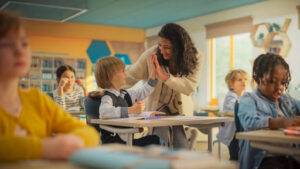 A teacher high-fiving a young student.