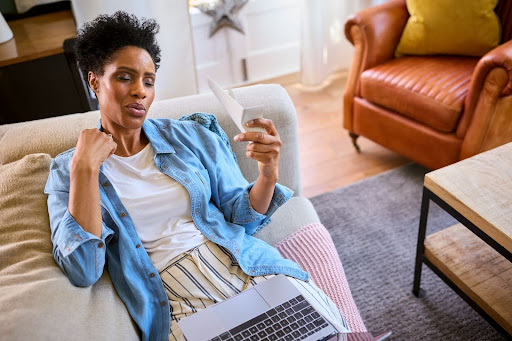 A woman fanning herself on a couch.