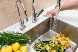 Food in sink going down the garbage disposal.